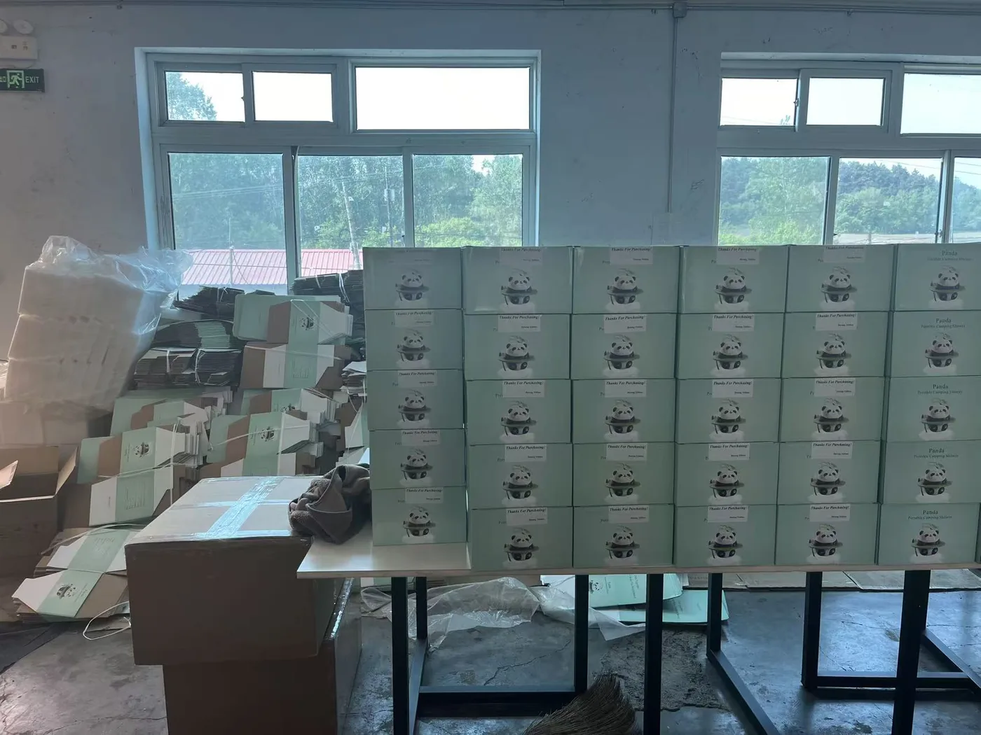Stacks of printed retail boxes for the Panda portable camping shower, packed and ready to ship